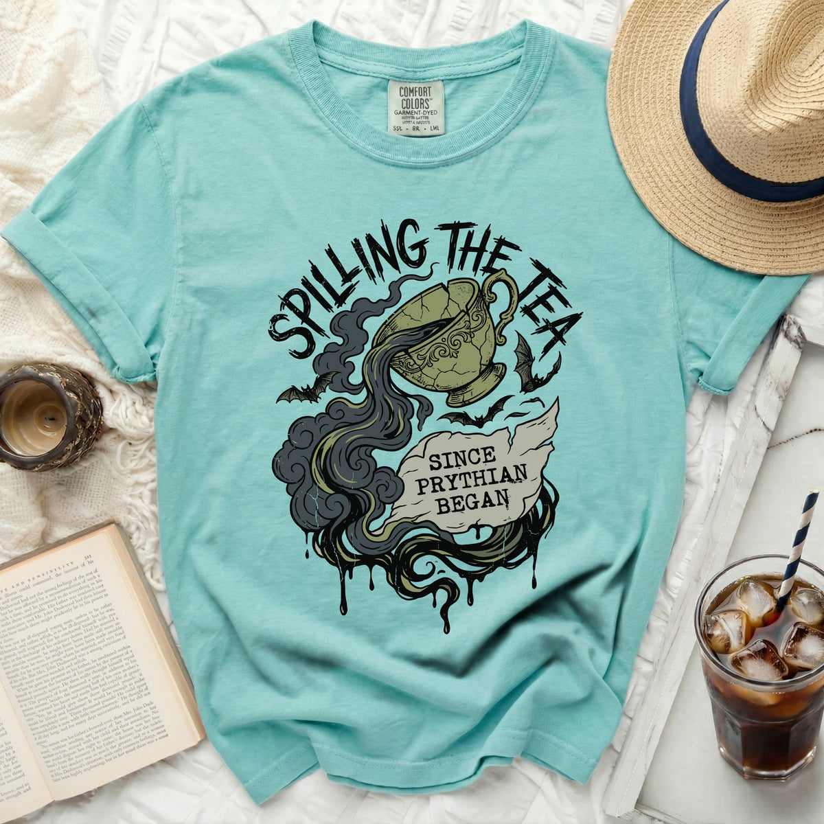 Turquoise t-shirt with "Spilling the Tea Since Pythian Began" graphic.