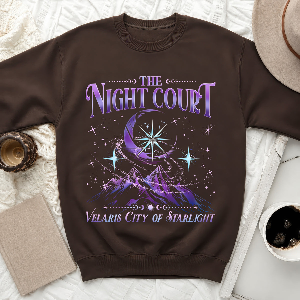Brown sweatshirt with "The Night Court Velaris City of Starlight" design.