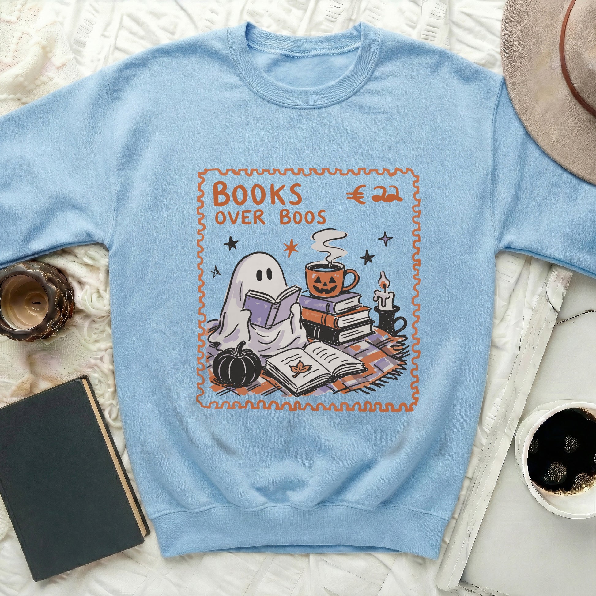 Light blue sweatshirt with "Books Over Boos" stamp graphic featuring a reading ghost.