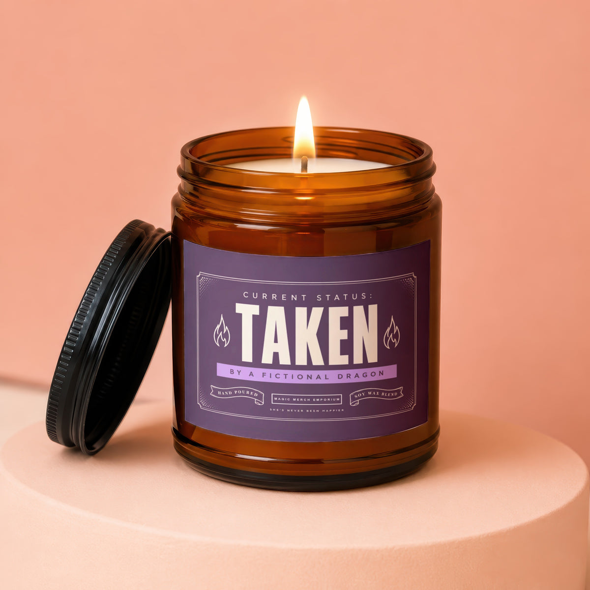Amber jar candle with purple label reading "TAKEN BY A FICTIONAL DRAGON"