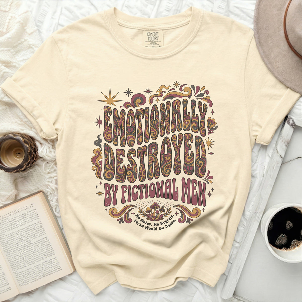 Cream t-shirt with "Emotionally Destroyed by Fictional Men" graphic.