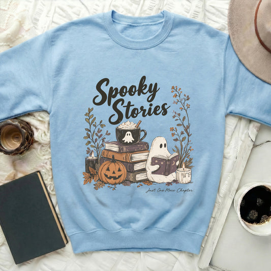 Light blue sweatshirt with "Spooky Stories" graphic featuring a ghost reading a book and Halloween decor.