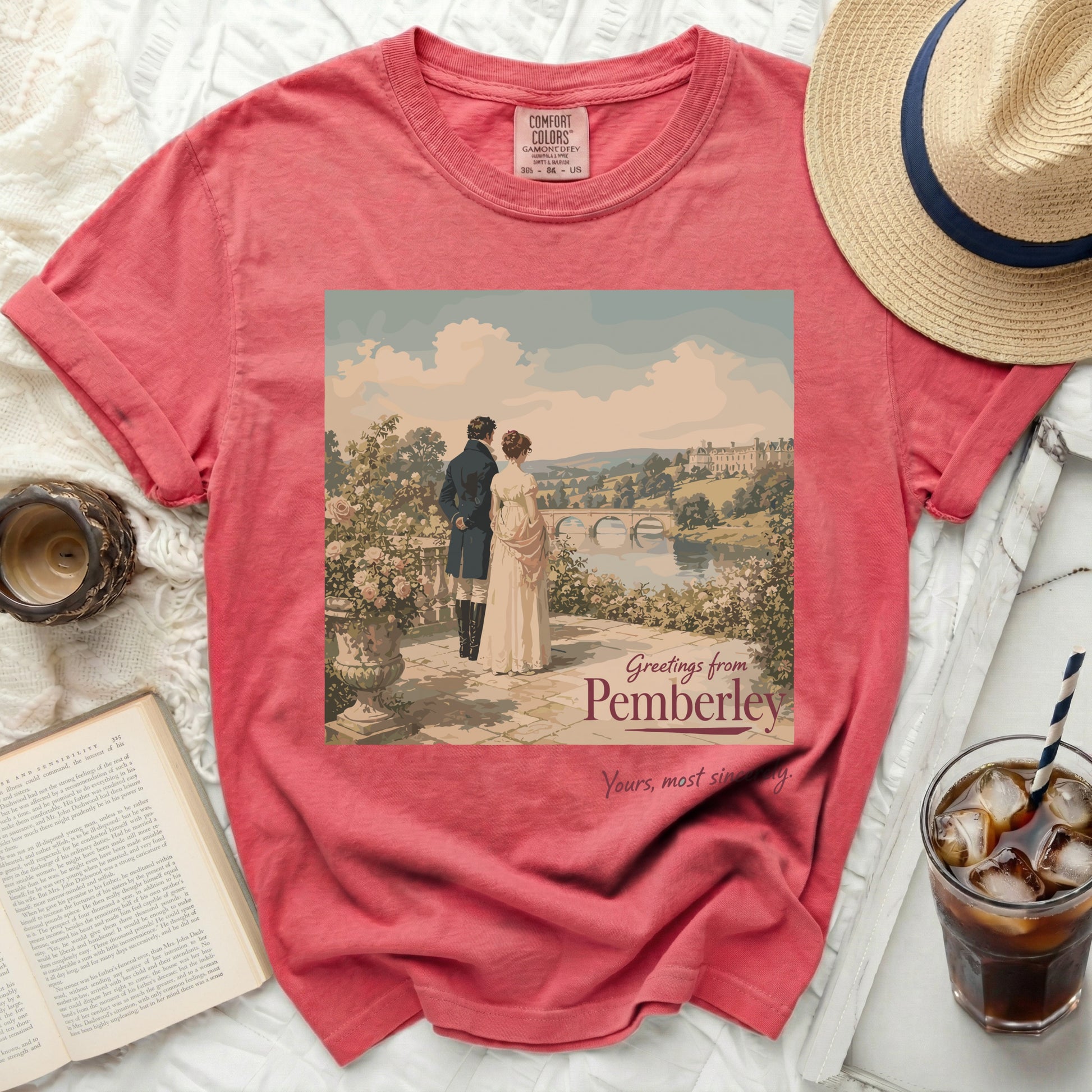 Coral t-shirt with "Greetings from Pemberley" print featuring a couple and estate.