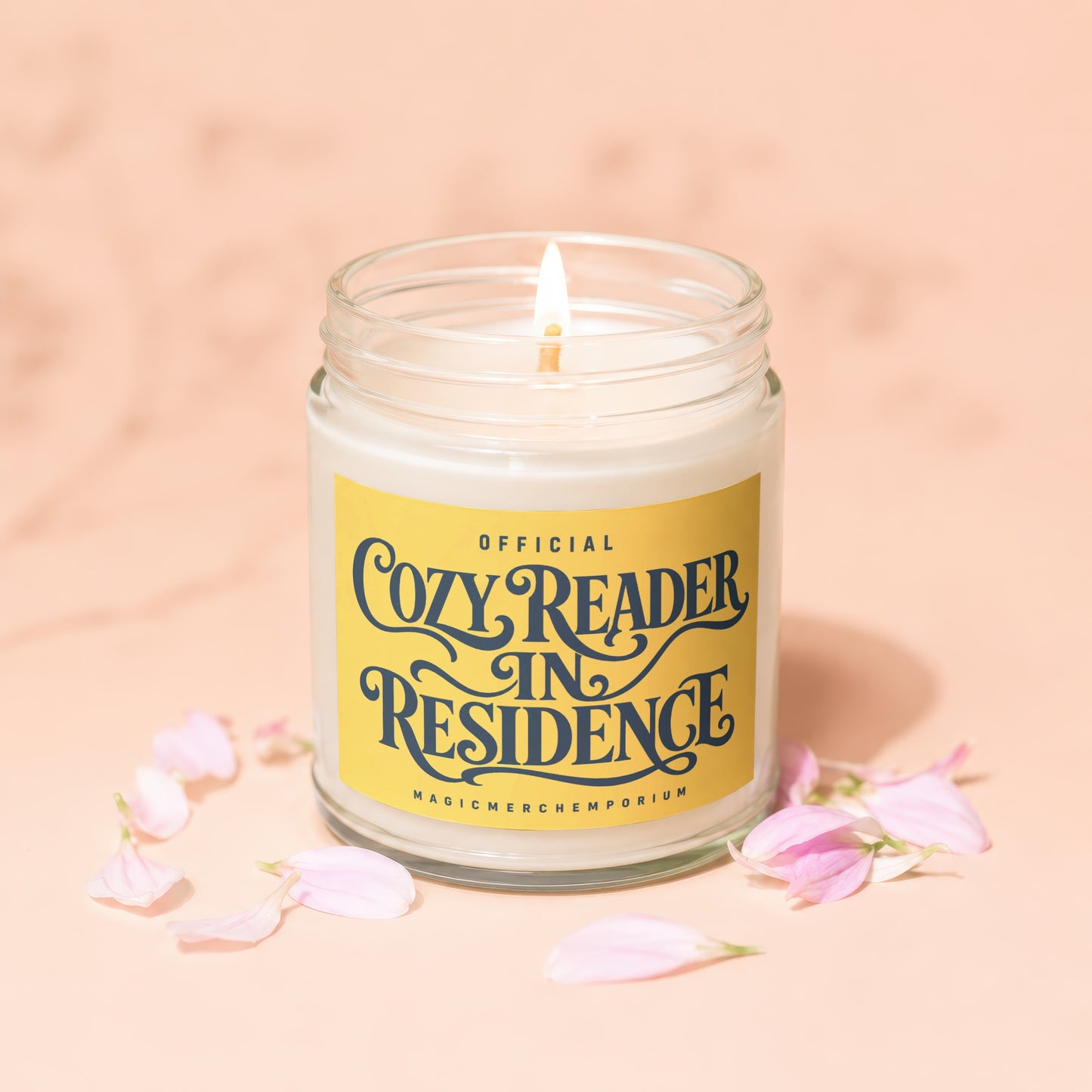 Candle with a yellow label reading "Official Cozy Reader In Residence."