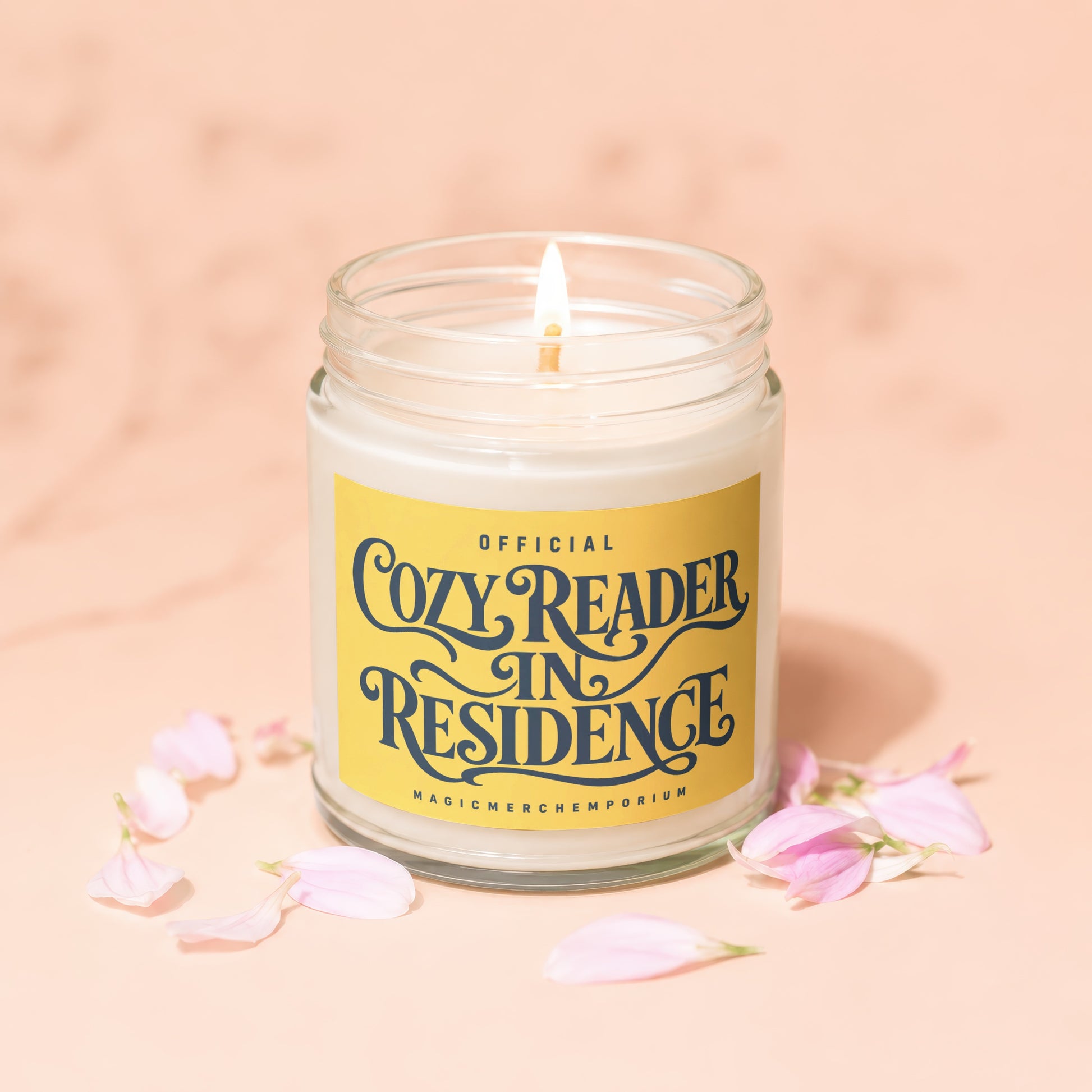 Candle with a yellow label reading "Official Cozy Reader In Residence."