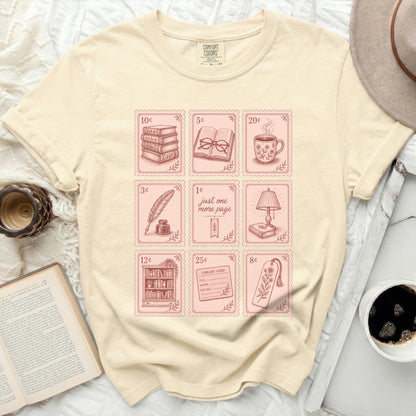 Cream t-shirt with pink book-themed icons and stamps.