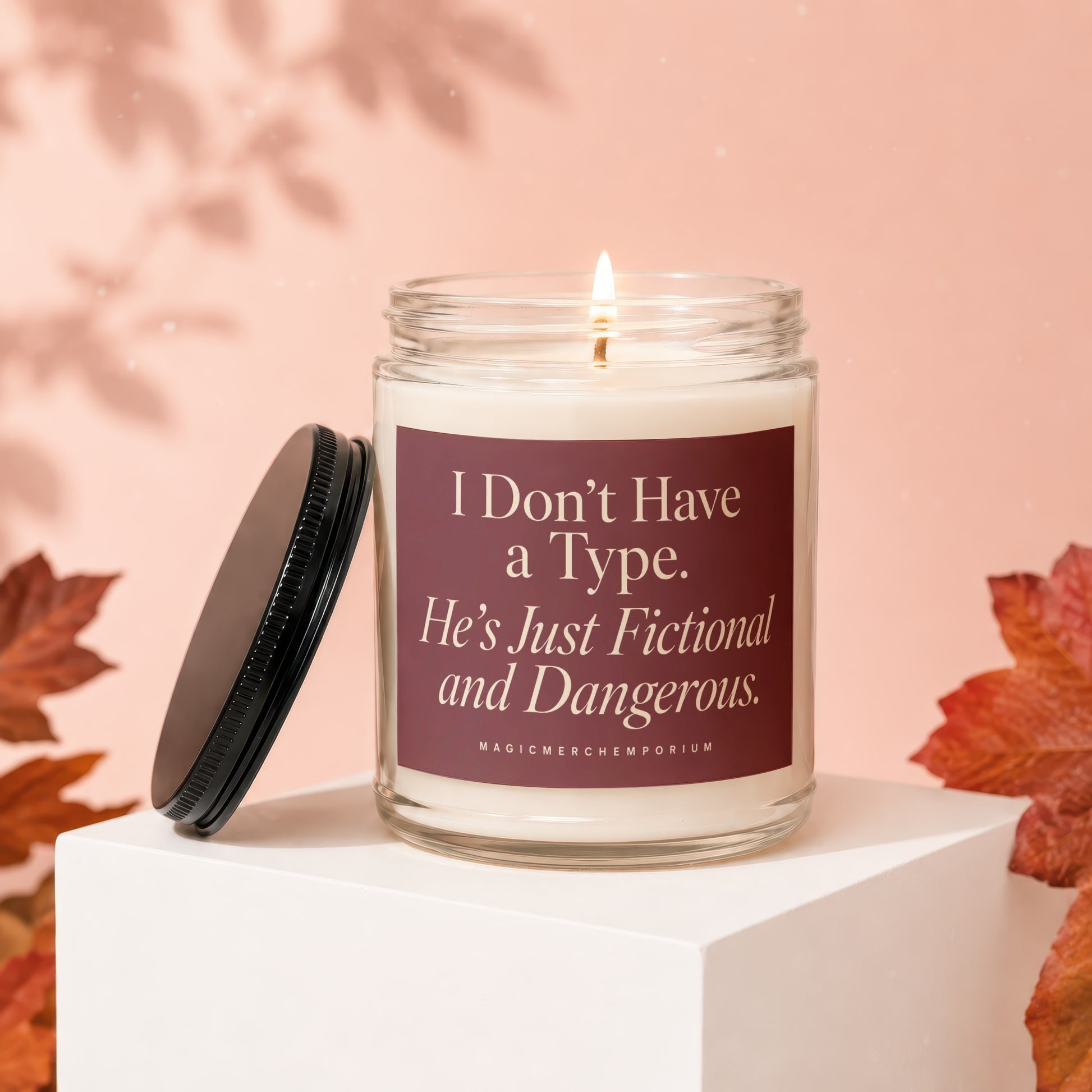Glass candle with lit wick and lid off, featuring text "I Don't Have a Type. He's Just Fictional and Dangerous."