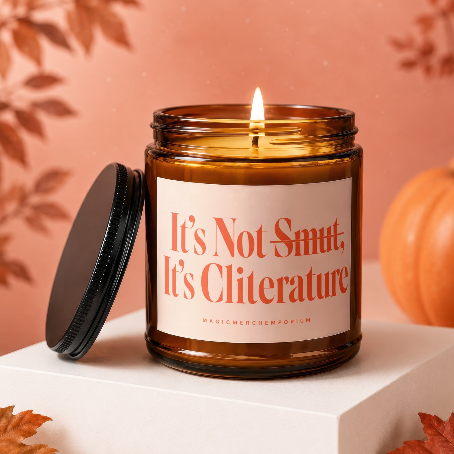 Amber glass candle with lit wick, reads "It's Not Smut, It's Cliterature".