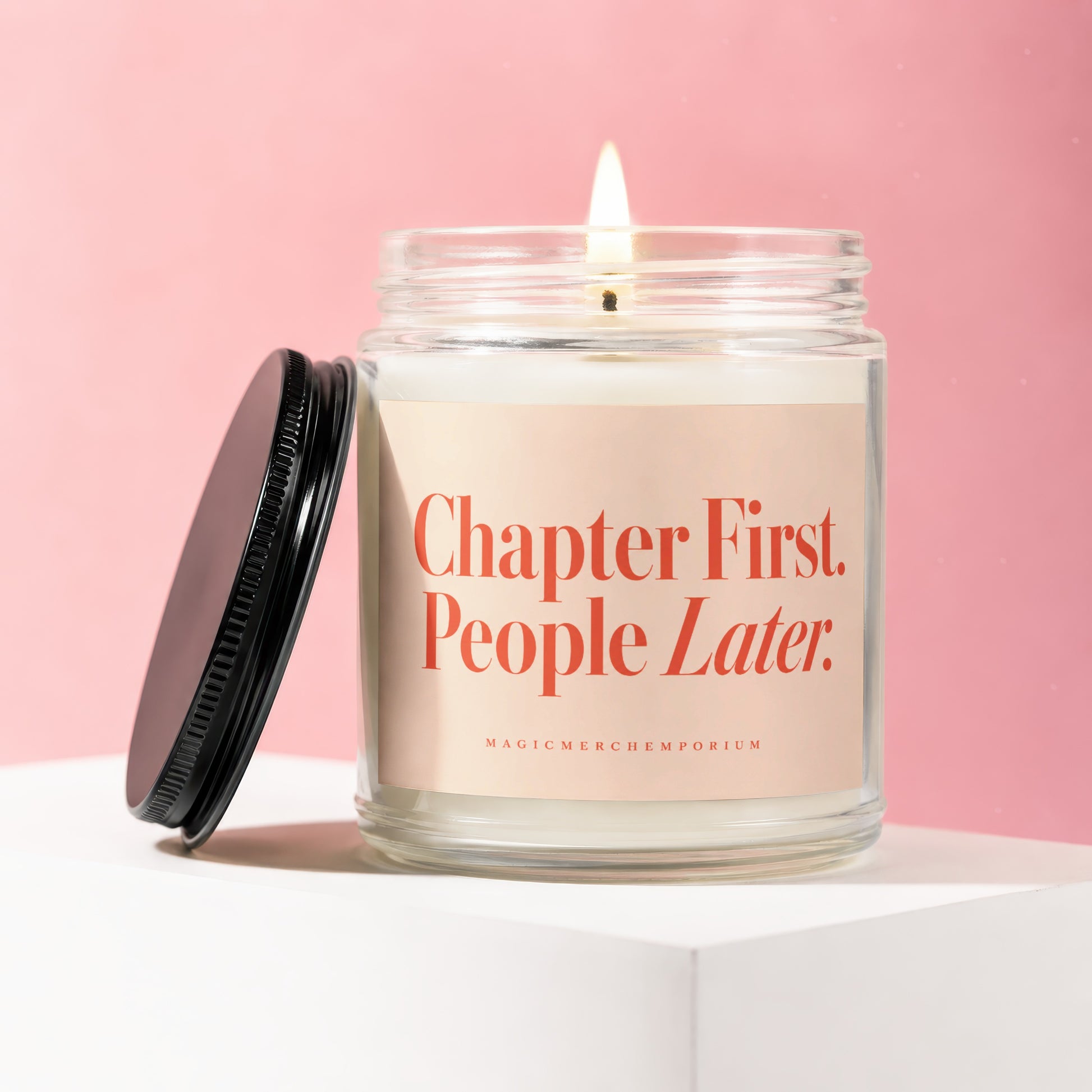 Jar candle with lit wick and label reading "Chapter First. People Later."