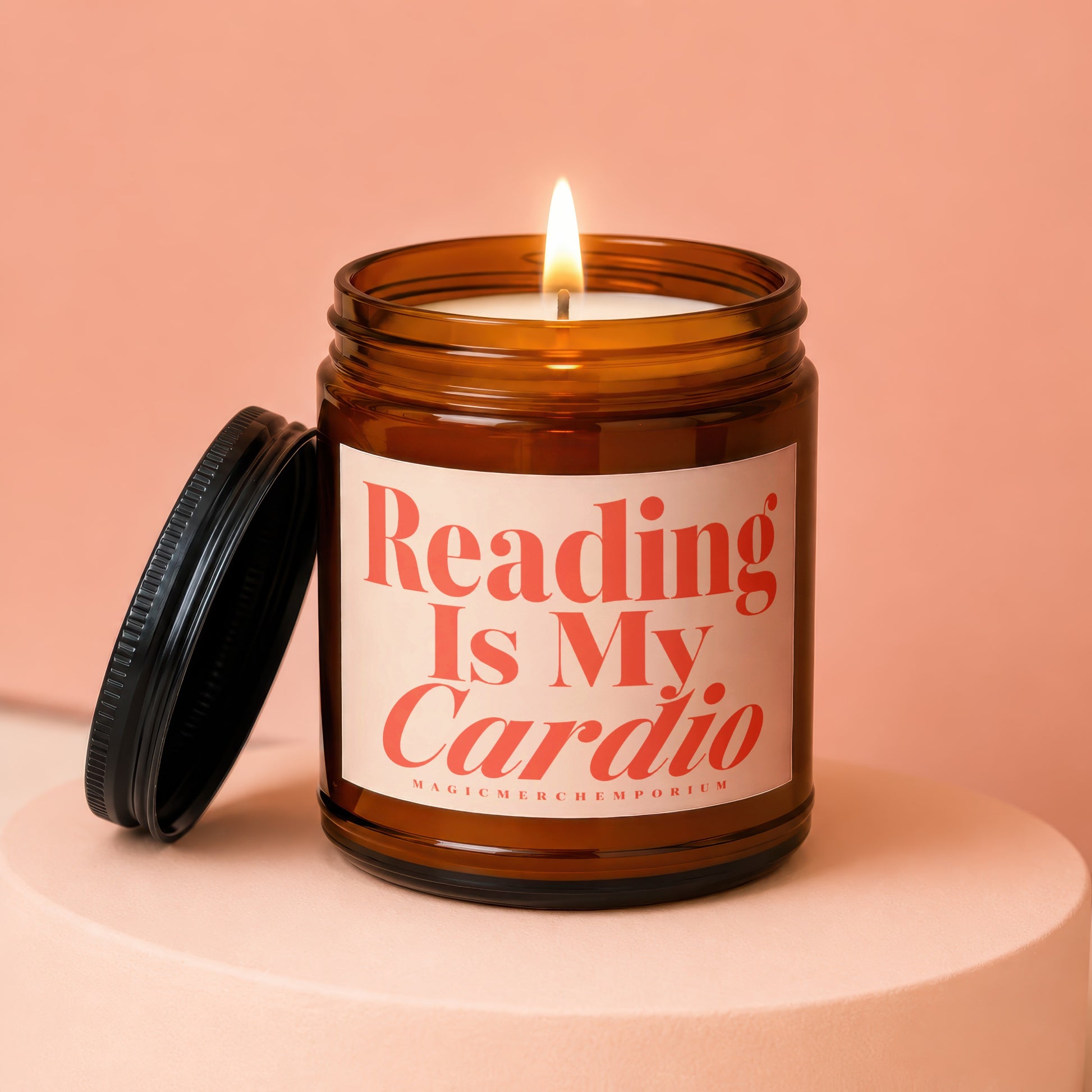 Amber jar candle with lit wick and lid off, saying "Reading Is My Cardio".