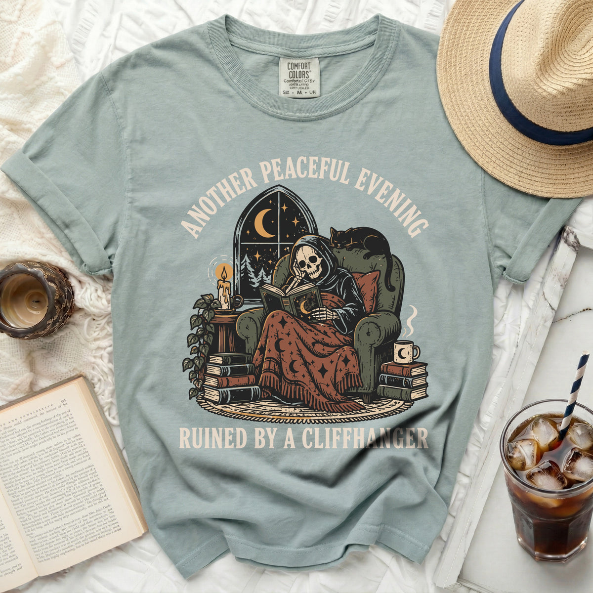 Grim reaper reading a book with a cat, text: Another Peaceful Evening Ruined By A Cliffhanger.