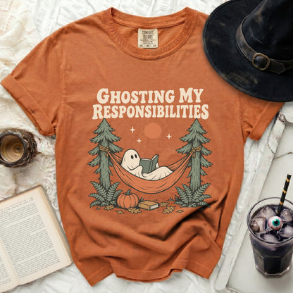 Orange t-shirt with ghost reading in a hammock and text "Ghosting My Responsibilities".