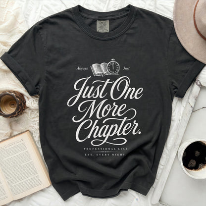 Dark t-shirt with "Just One More Chapter" and "Professional Liar" text.