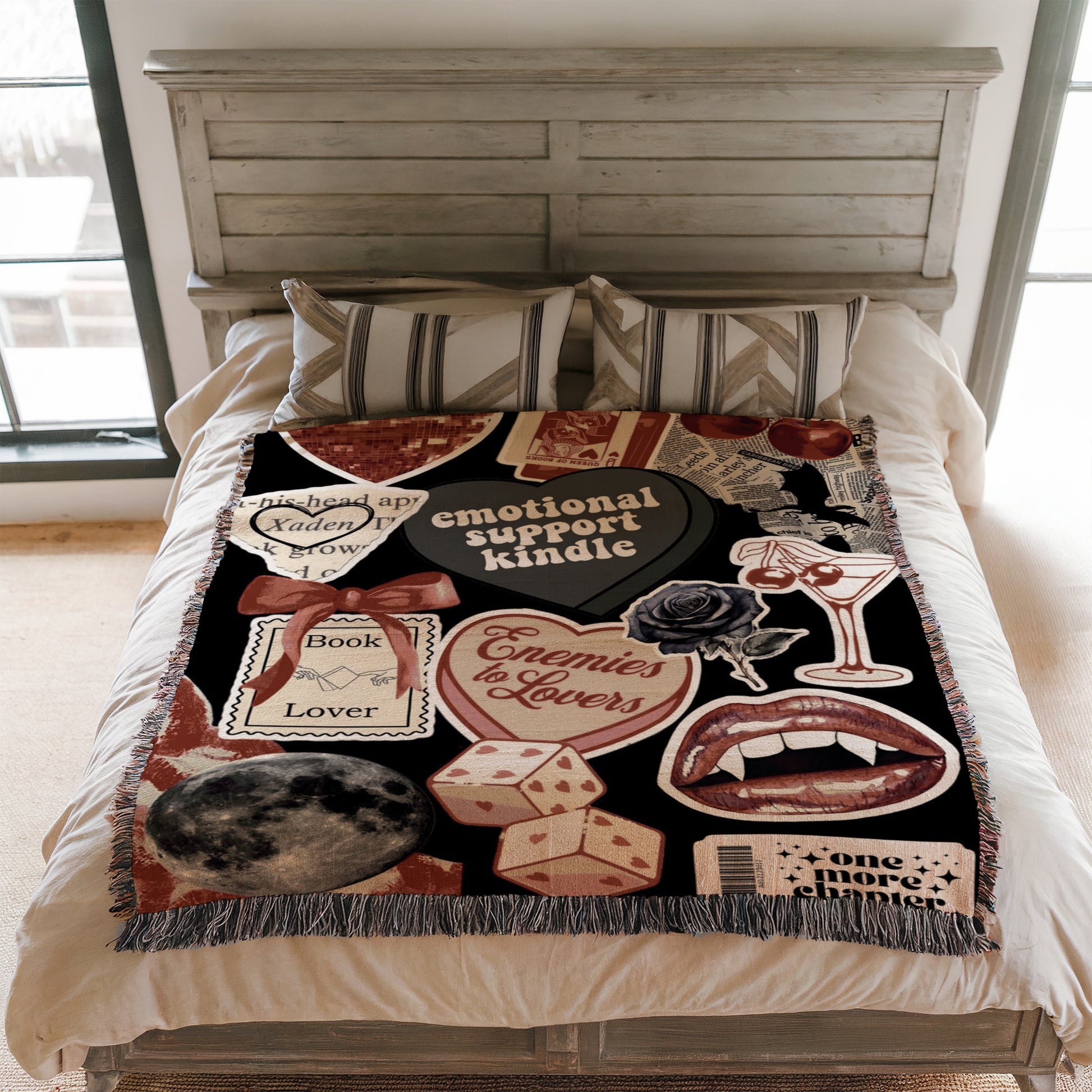 a bedroom with a bed covered in a colorful, patterned blanket that includes various objects such as a heart, a rose, a book, and a wine glass.