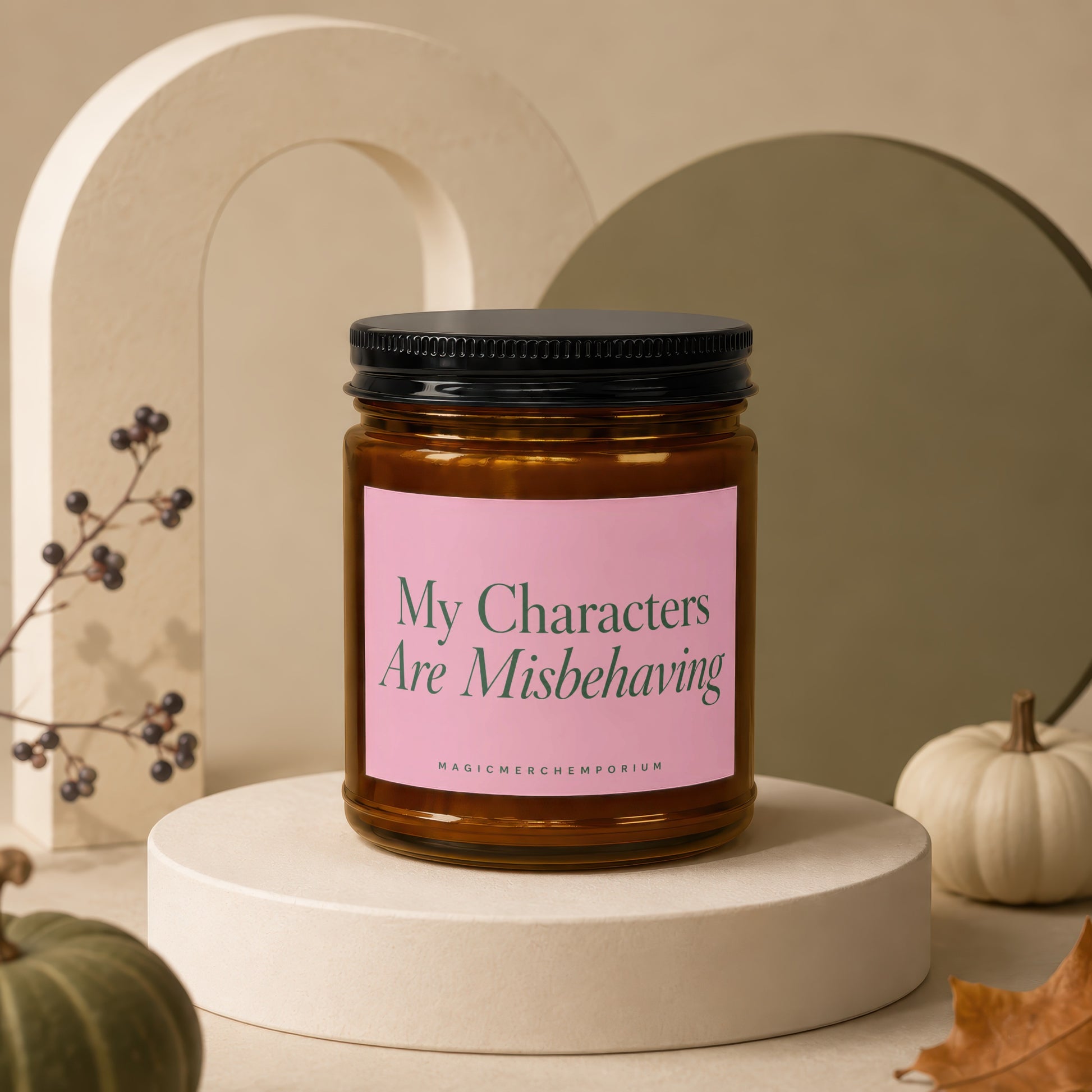 Amber jar candle with pink label reading "My Characters Are Misbehaving," by MagicMerch Emporium.