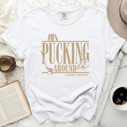 White t-shirt with "Pucking Around A Hockey Romance" text and graphics.