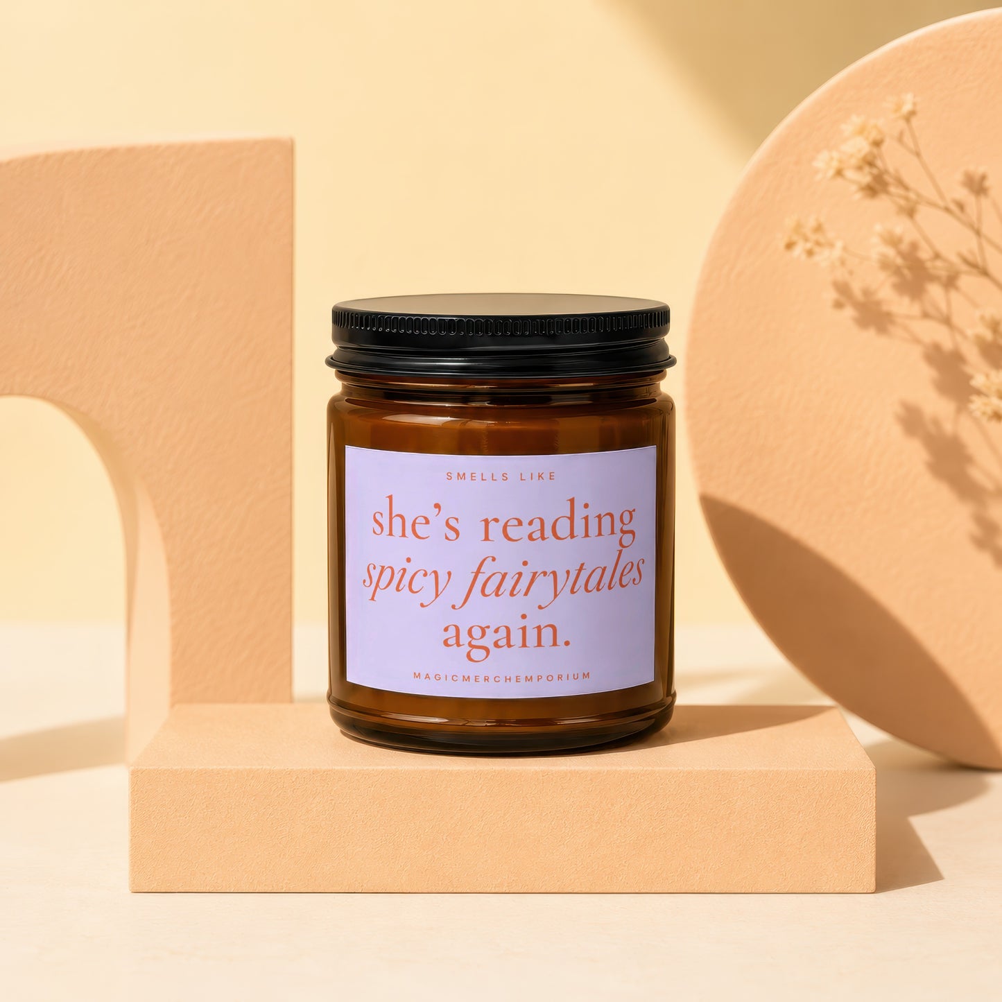 Amber glass candle with a black lid and white label that reads "she's reading spicy fairytales again."