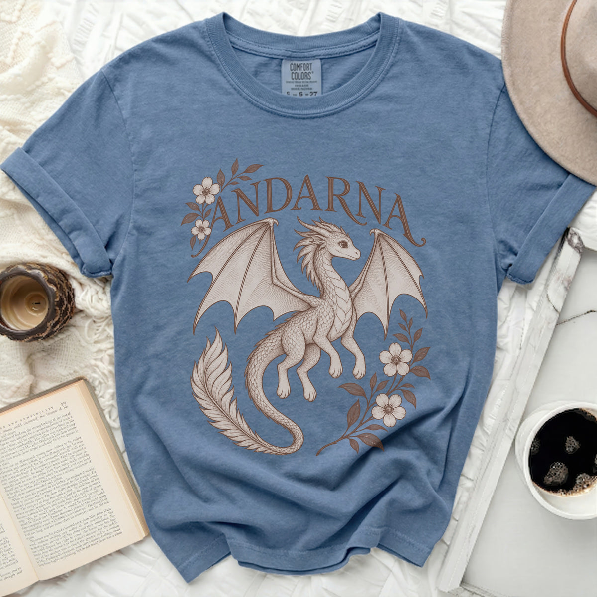 Blue crewneck t-shirt featuring a brown graphic of a dragon, flowers, and the word Andarna.