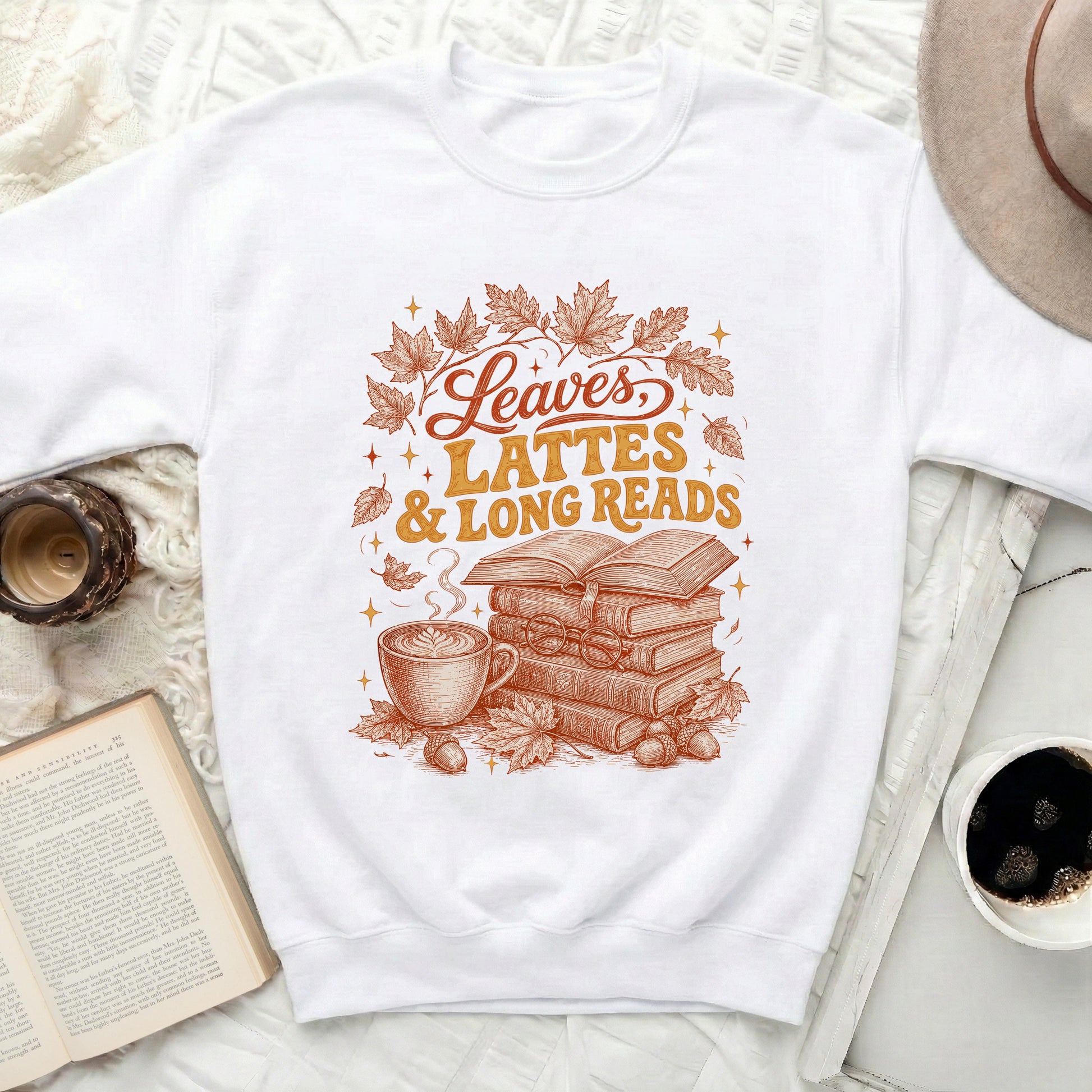 White sweatshirt with "Leaves, Lattes & Long Reads" graphic.