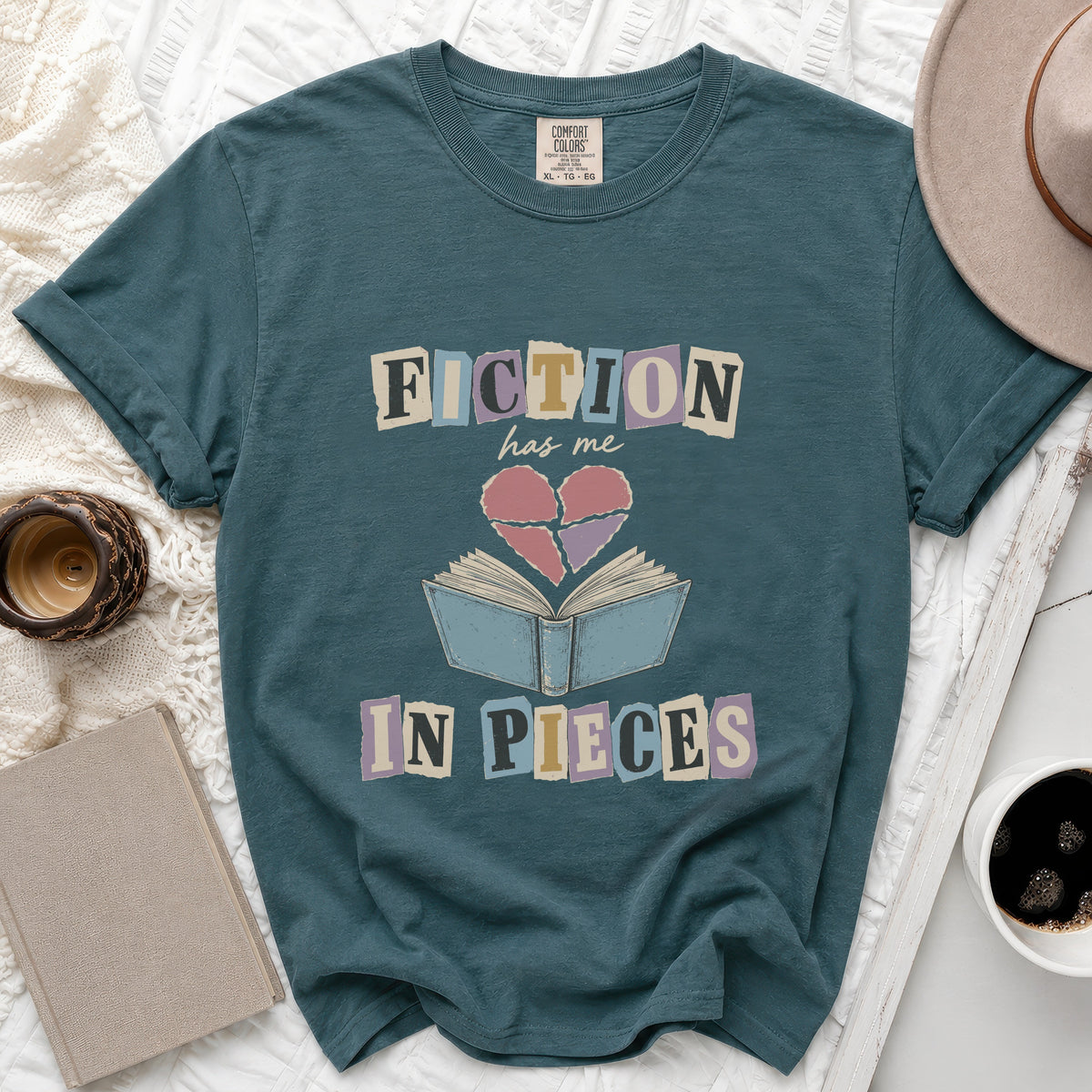 Teal t-shirt with "FICTION has me IN PIECES" text and broken heart over book graphic.