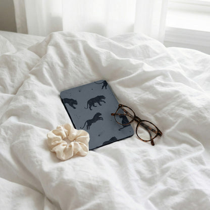 Notebook with tiger pattern, glasses, and scrunchie on white rumpled bedding with window light.