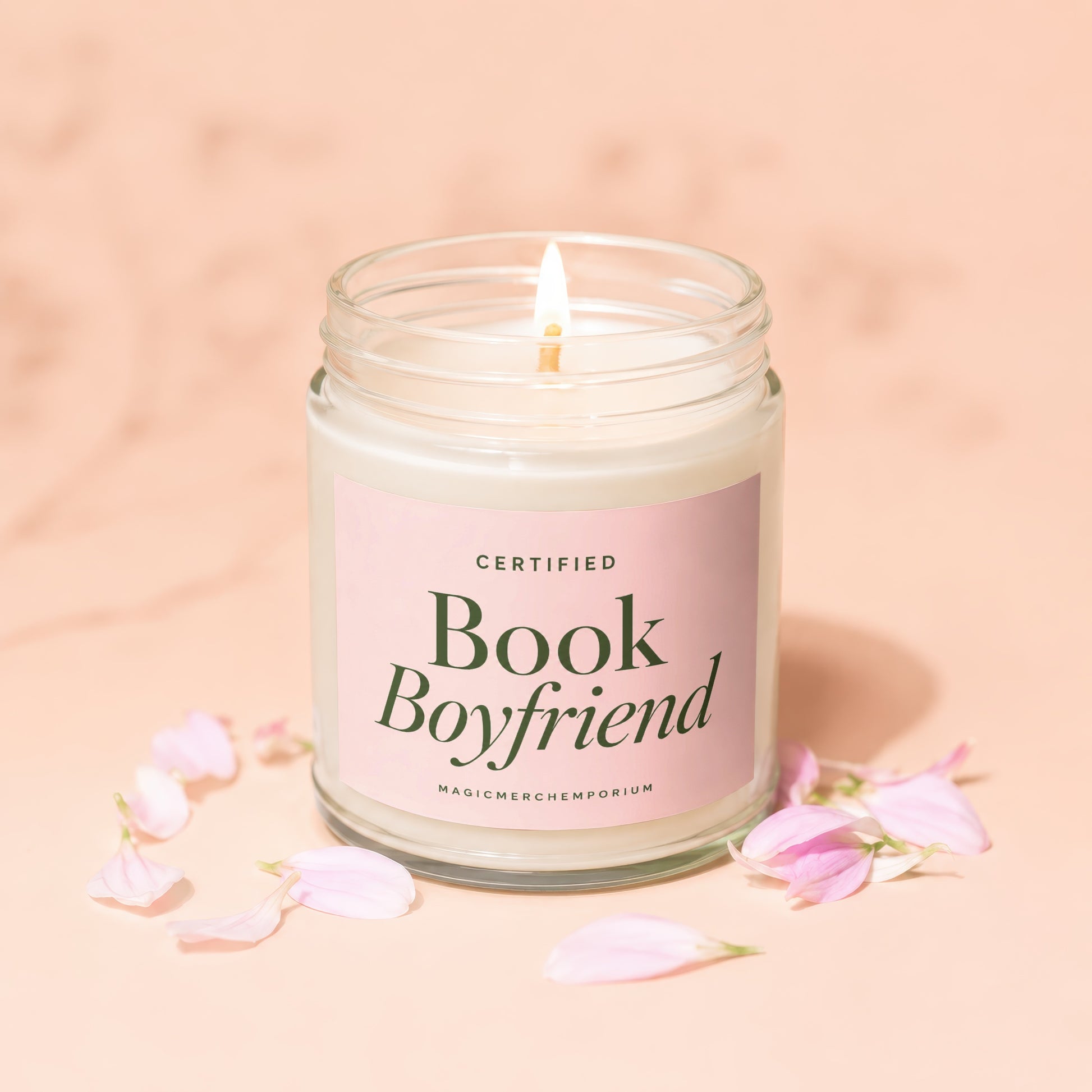 Glass jar candle with pink label that reads "CERTIFIED Book Boyfriend" and "MAGICMERCH”.