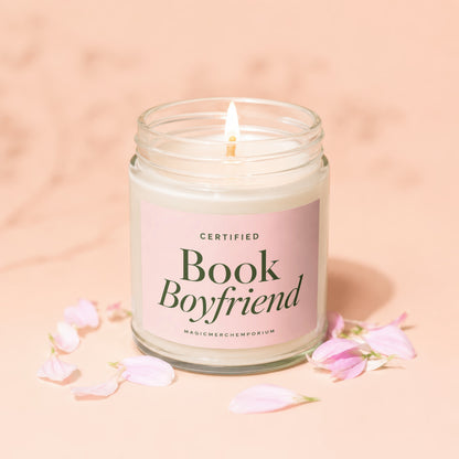 Glass jar candle with pink label that reads "CERTIFIED Book Boyfriend" and "MAGICMERCH”.