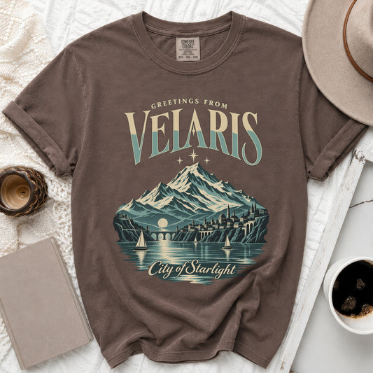Brown t-shirt with "Greetings from Velaris City of Starlight" graphic.