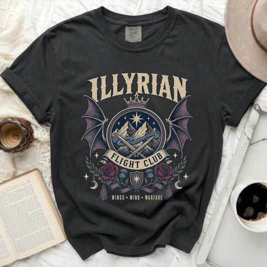 Dark t-shirt with "Illyrian Flight Club" graphic featuring wings, mountains, swords, and floral elements.