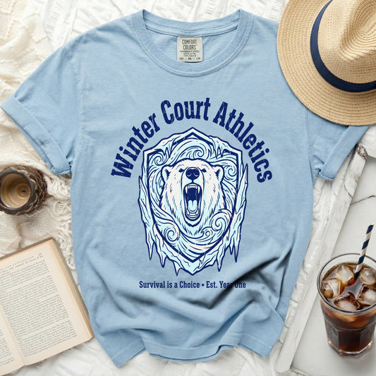 Light blue t-shirt with a roaring polar bear inside an icy shield, text "Winter Court Athletics" and "Survival is a Choice Est. Year One".