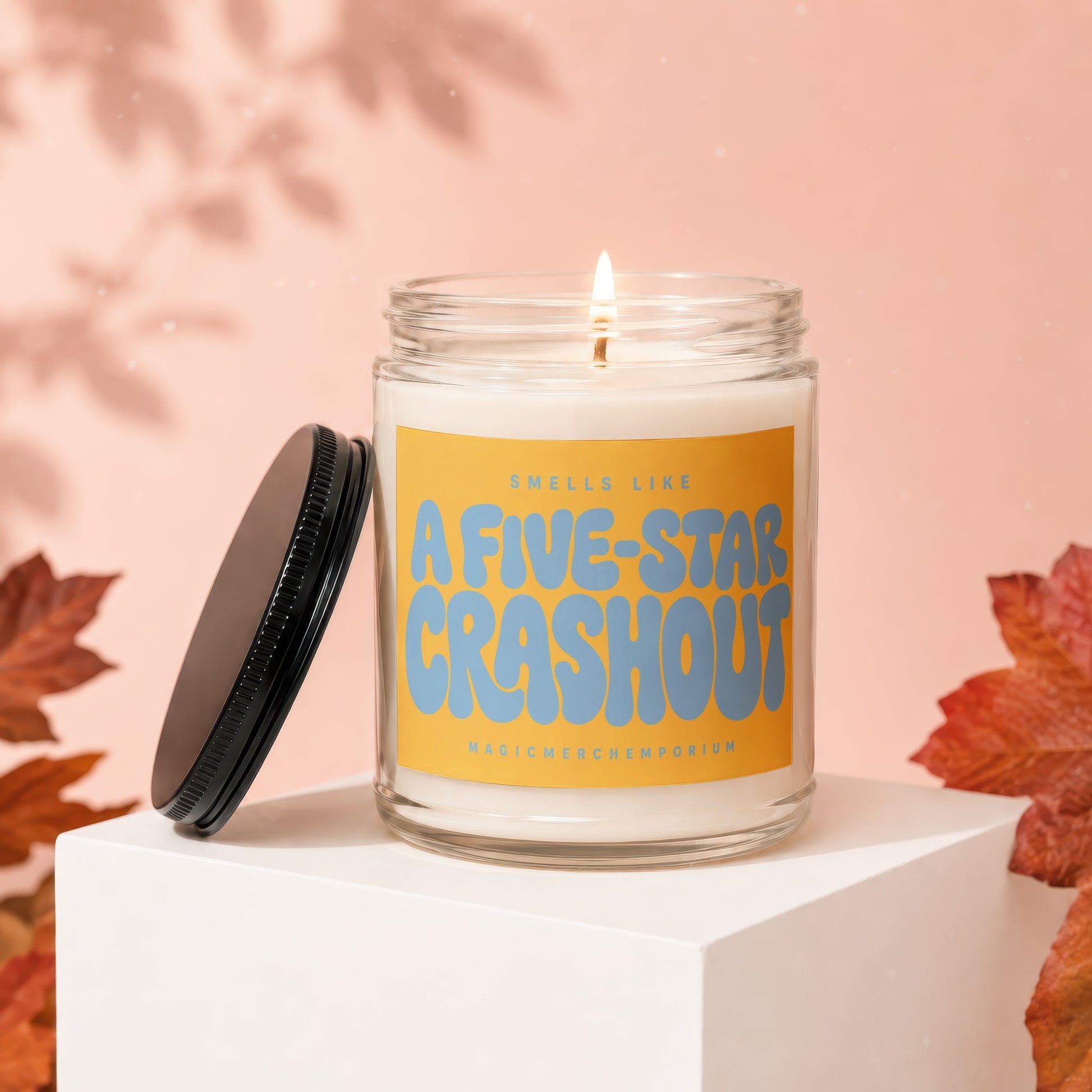 Candle with "Smells Like A Five-Star Crashout" text and "MagicMerchEmporium" logo.