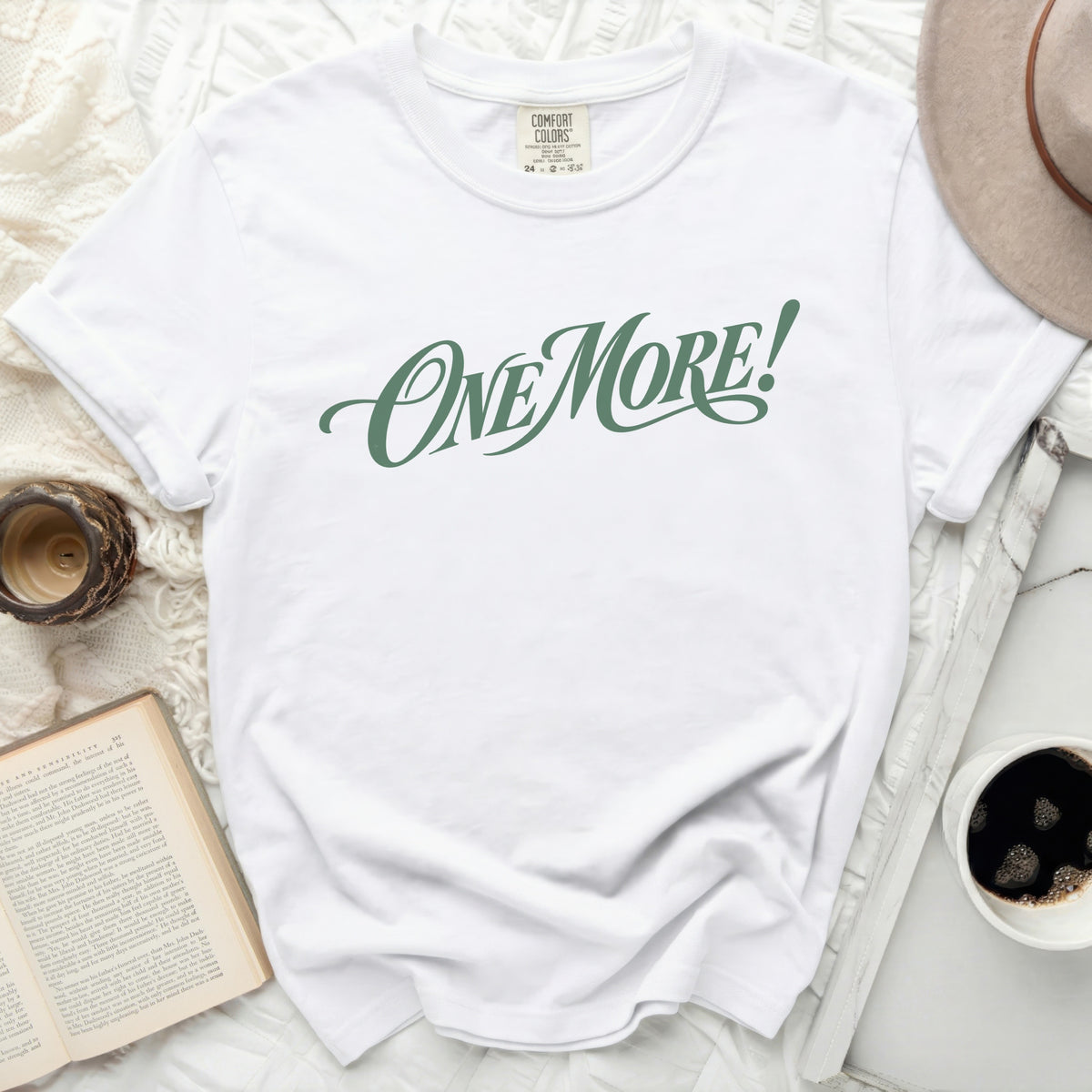 White Comfort Colors t-shirt with "ONE MORE!" graphic in green script.