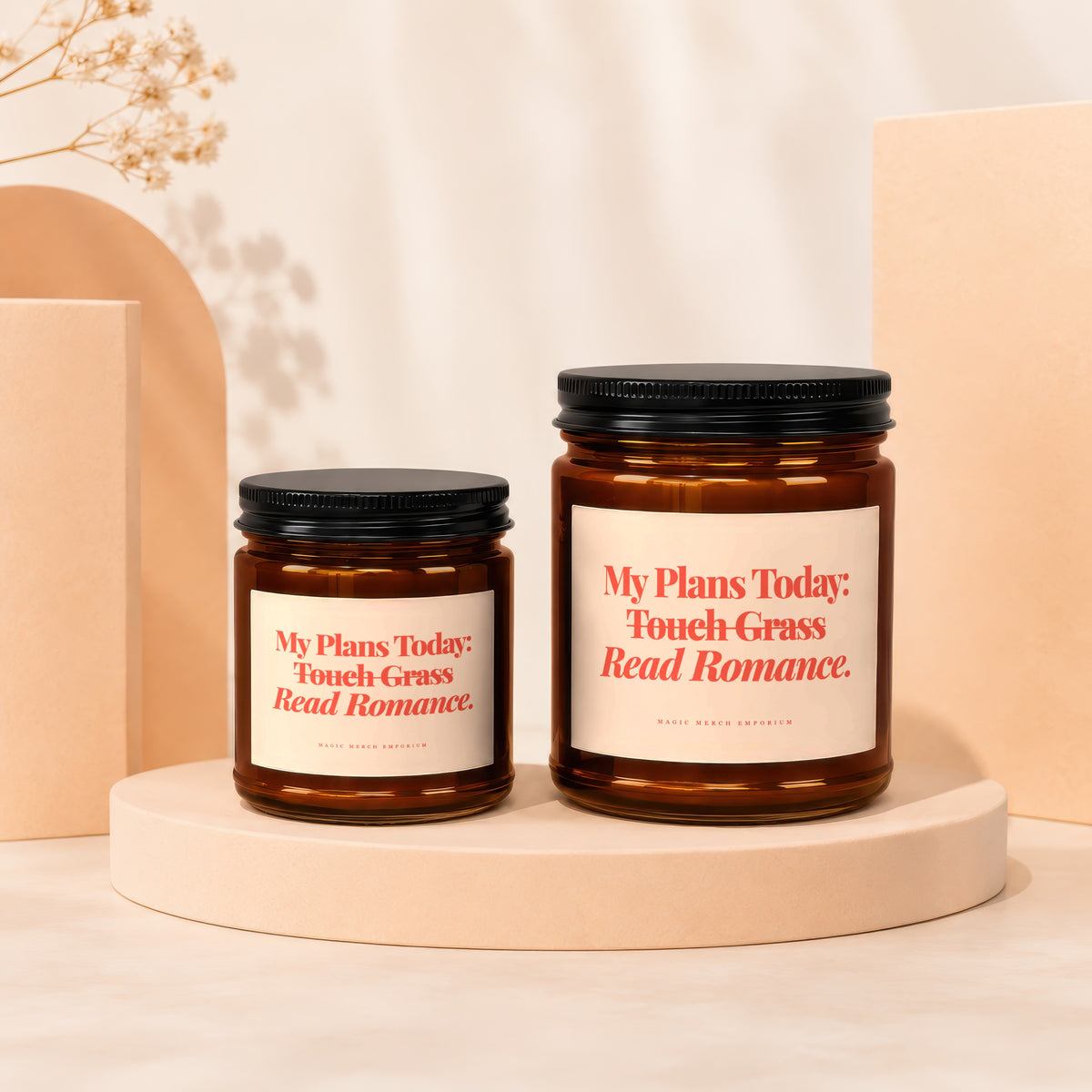 Two amber glass candles with white labels featuring red text and black lids.