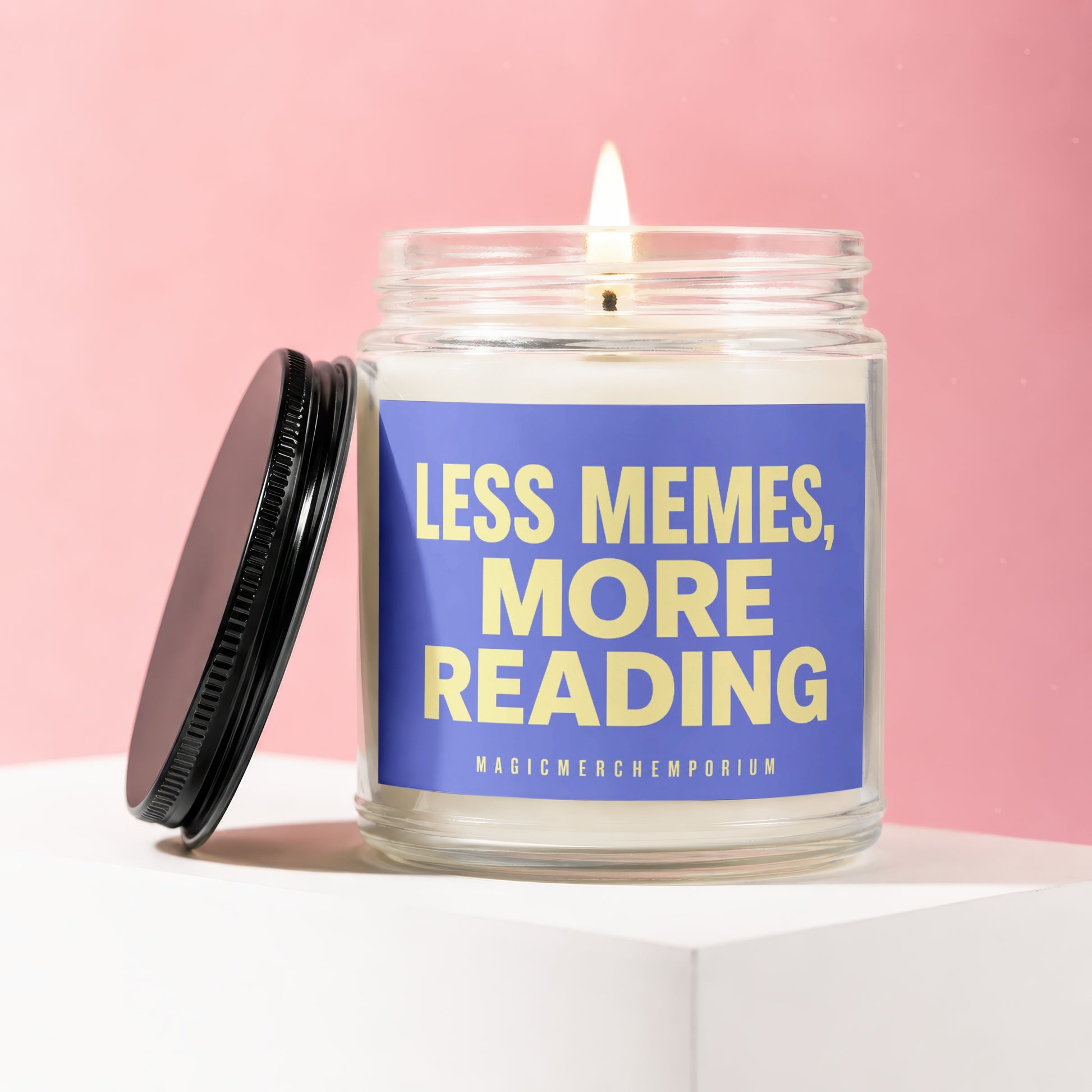 Lit candle in jar with blue label reading "LESS MEMES, MORE READING"