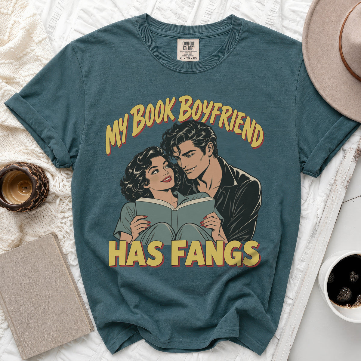 Teal t-shirt with vintage comic art of a couple reading, "My Book Boyfriend Has Fangs."