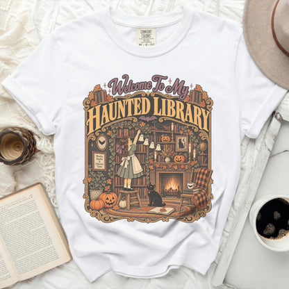 White t-shirt with "Welcome To My Haunted Library" graphic and Halloween-themed scene.