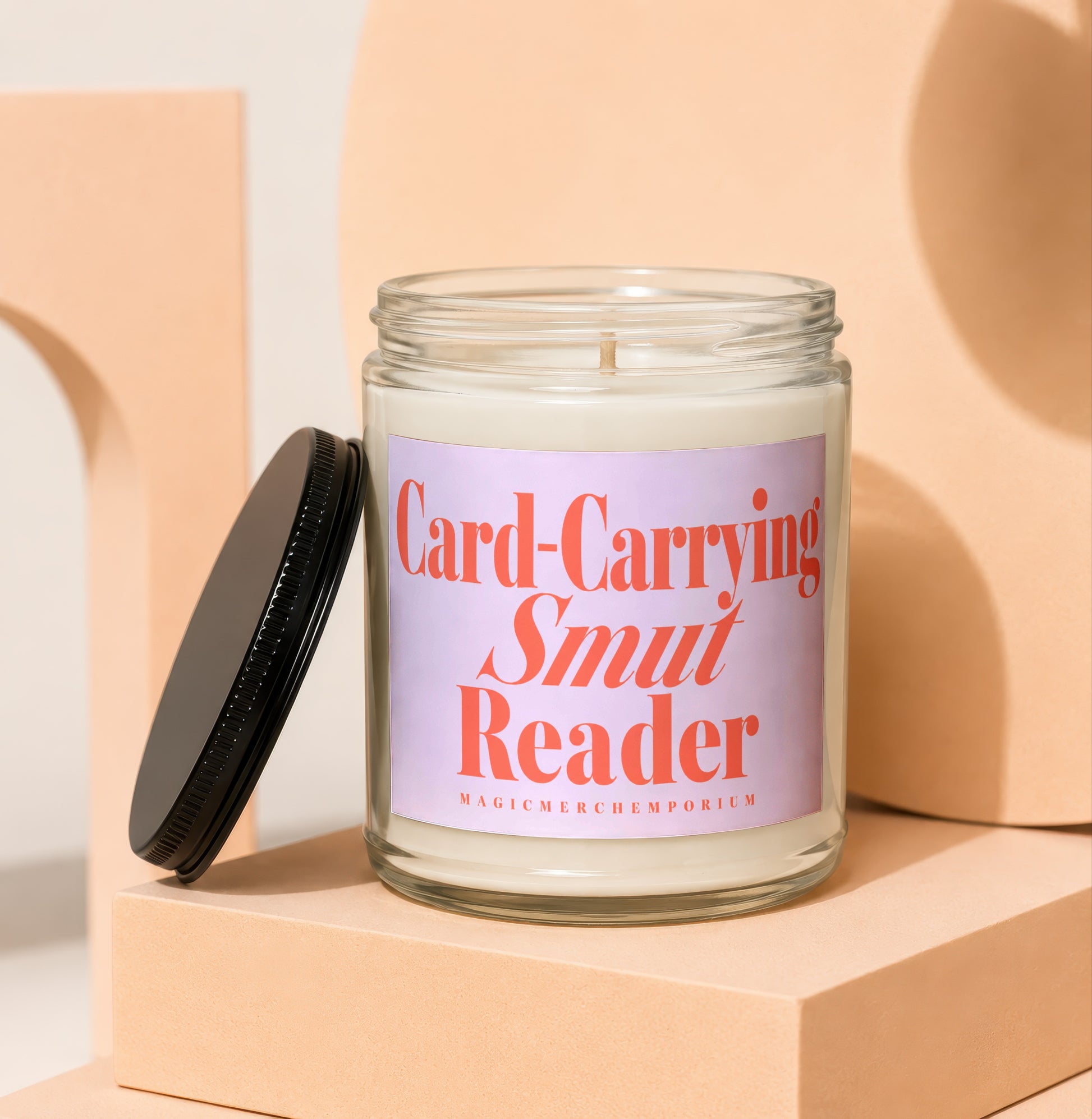 Candle with "Card-Carrying Smut Reader" text on a light purple label.