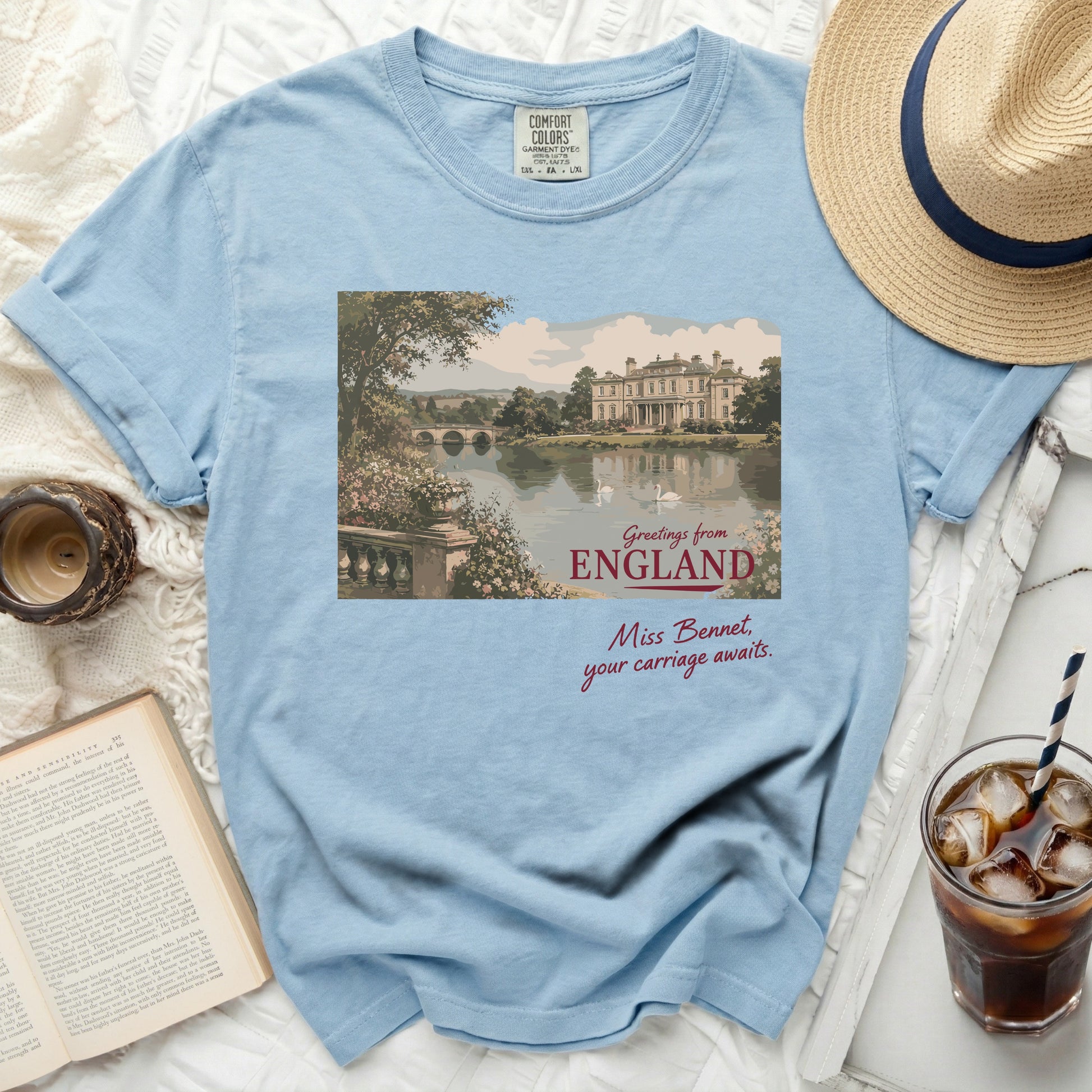 Light blue t-shirt with a vintage illustration of a manor and lake.