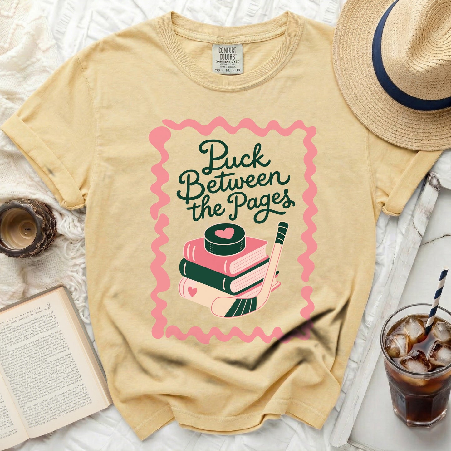 Yellow t-shirt with "Puck Between the Pages" and hockey puck.