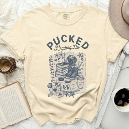 Cream t-shirt with "Pucked Reading List" text and hockey illustration.