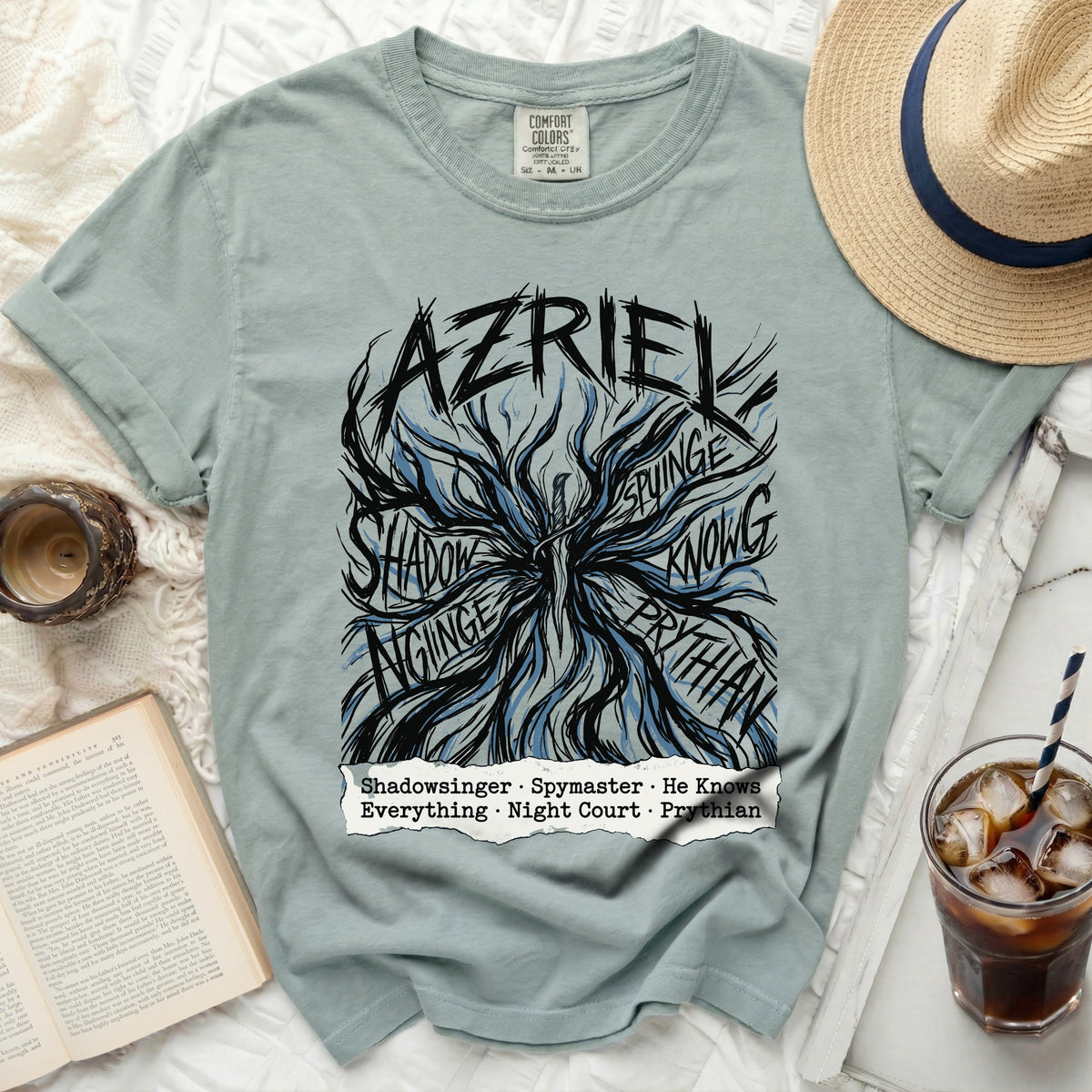 Light blue t-shirt with "AZRIEL" text and abstract design, and subtitle.