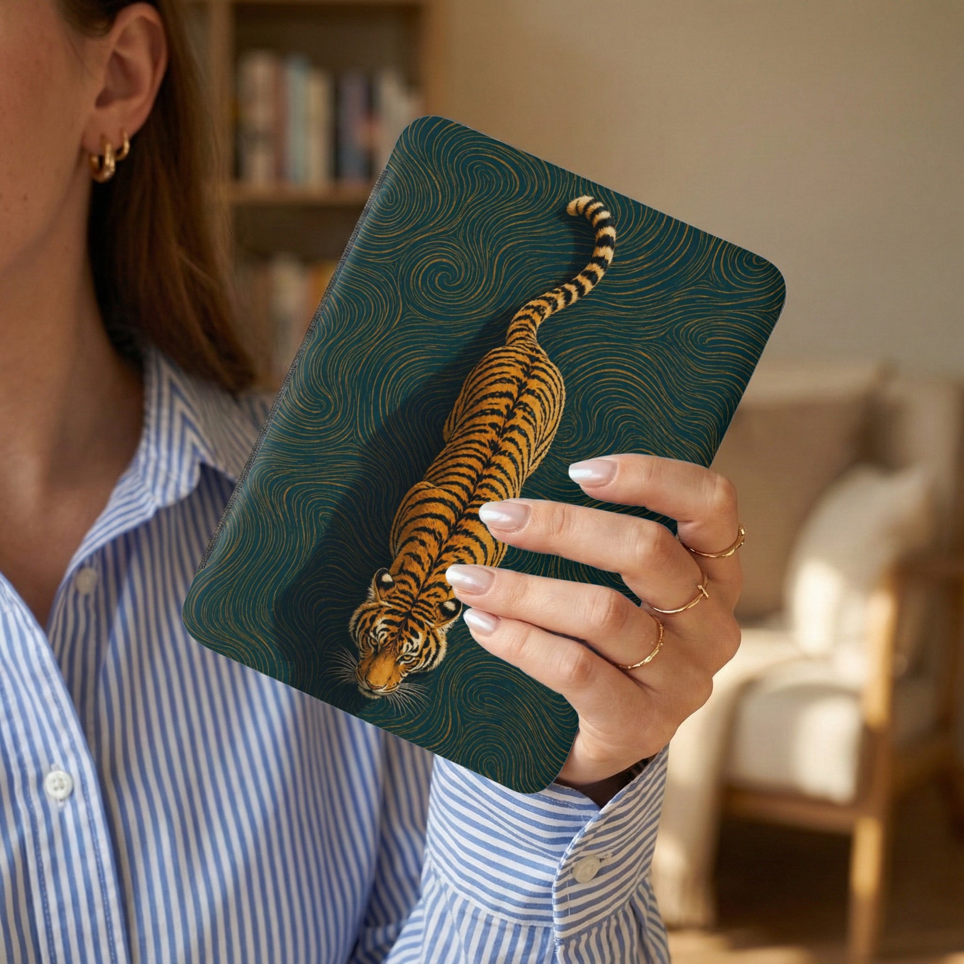 Tiger illustration on dark green wavy pattern case held by person in striped shirt