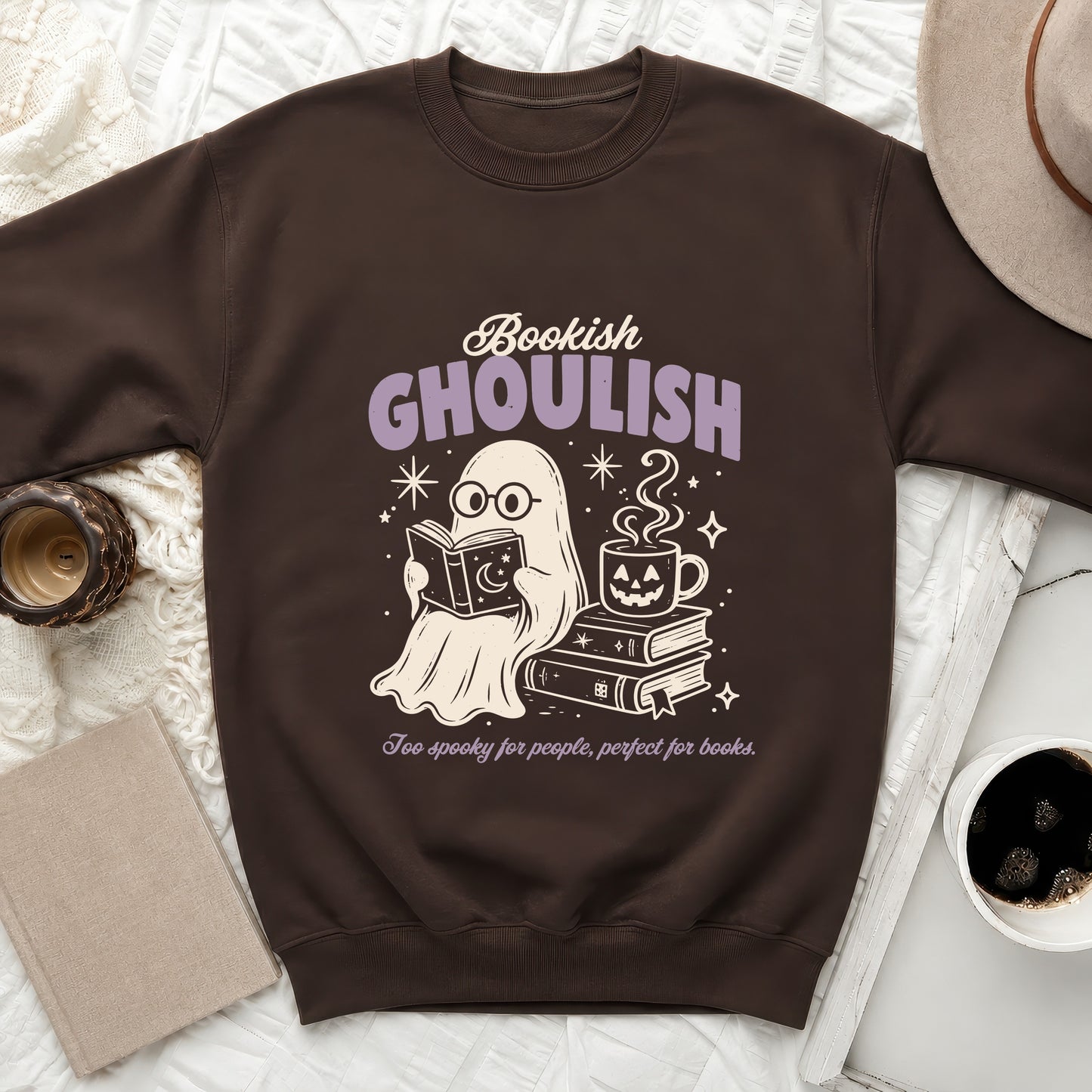 Brown sweatshirt with ghost reading, ghost mug, stacked books, and text.