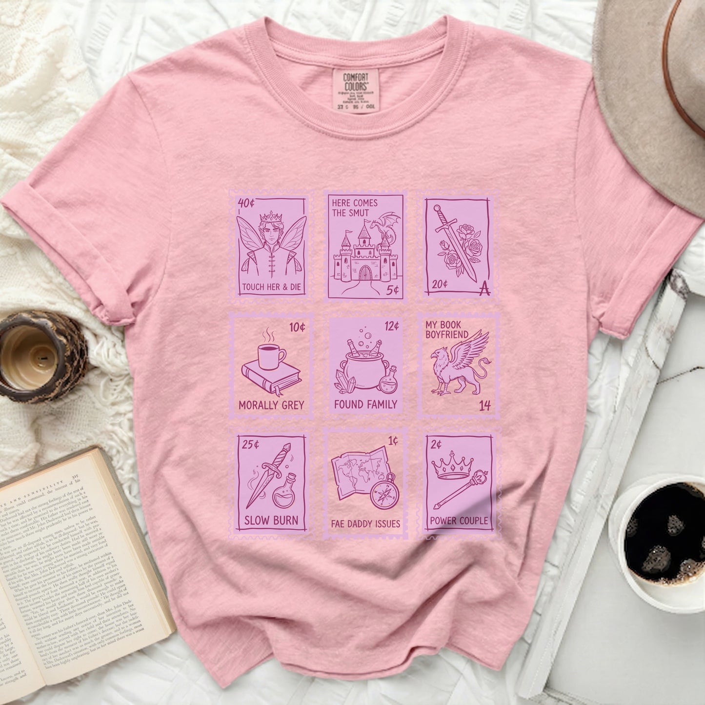 Pink Comfort Colors t-shirt with postage stamp designs and text about romance tropes.