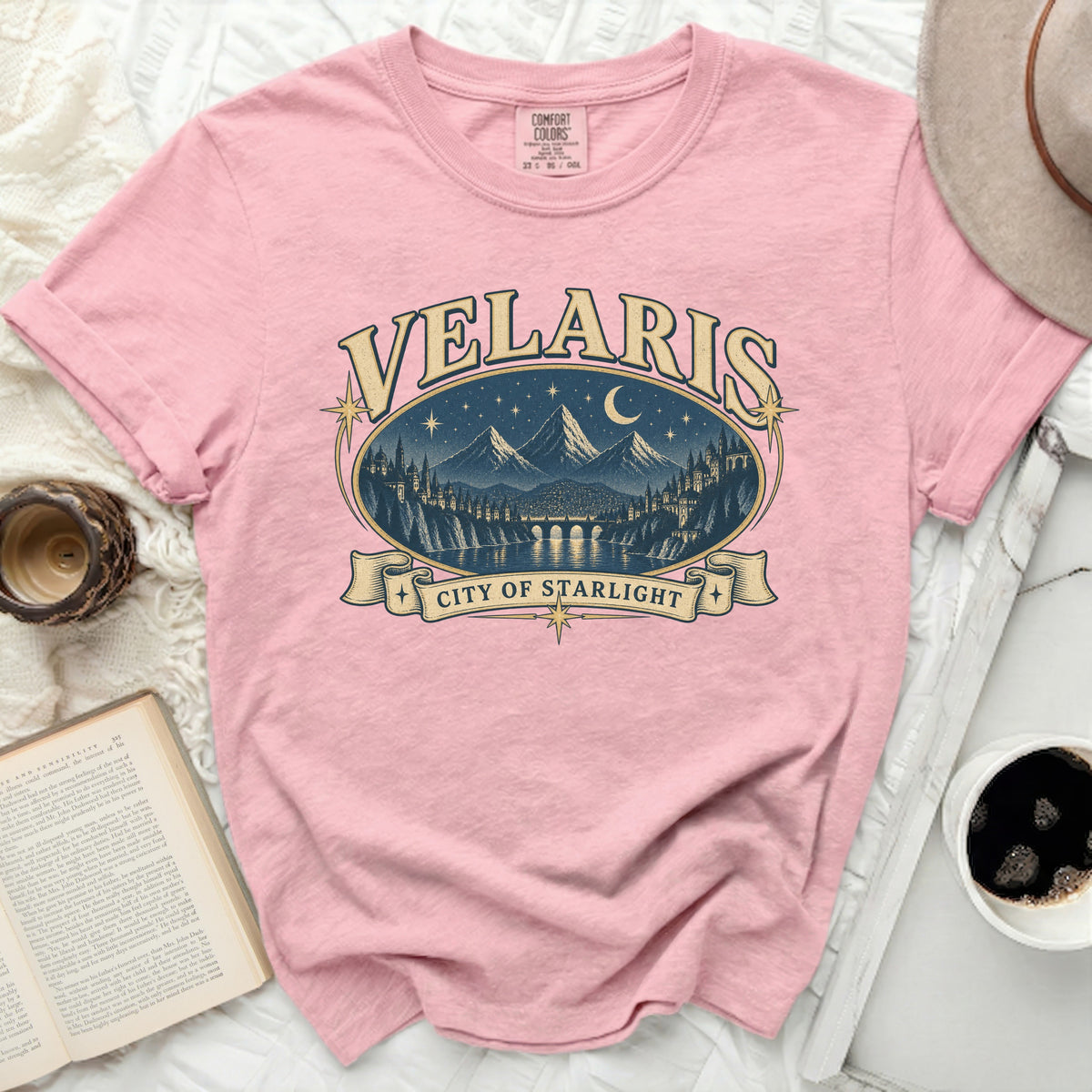 Pink t-shirt with "Velaris City of Starlight" graphic featuring a cityscape at night.