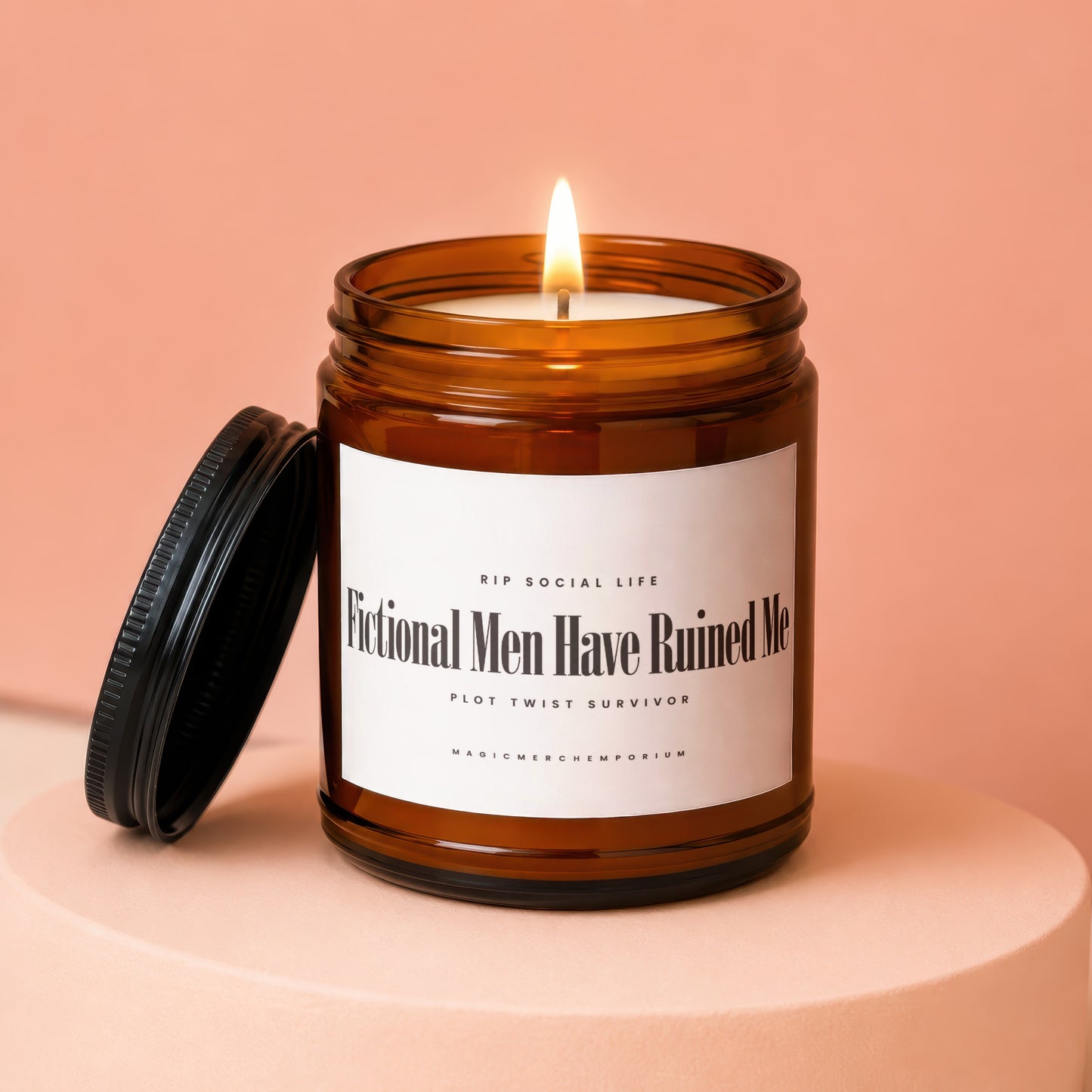 Amber glass candle with lit wick, black lid, and text "Fictional Men Have Ruined Me".