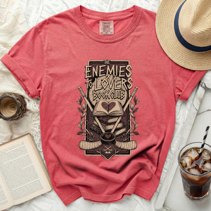 T-shirt with "The Enemies To Lovers Book Club" graphic featuring books and hockey sticks.
