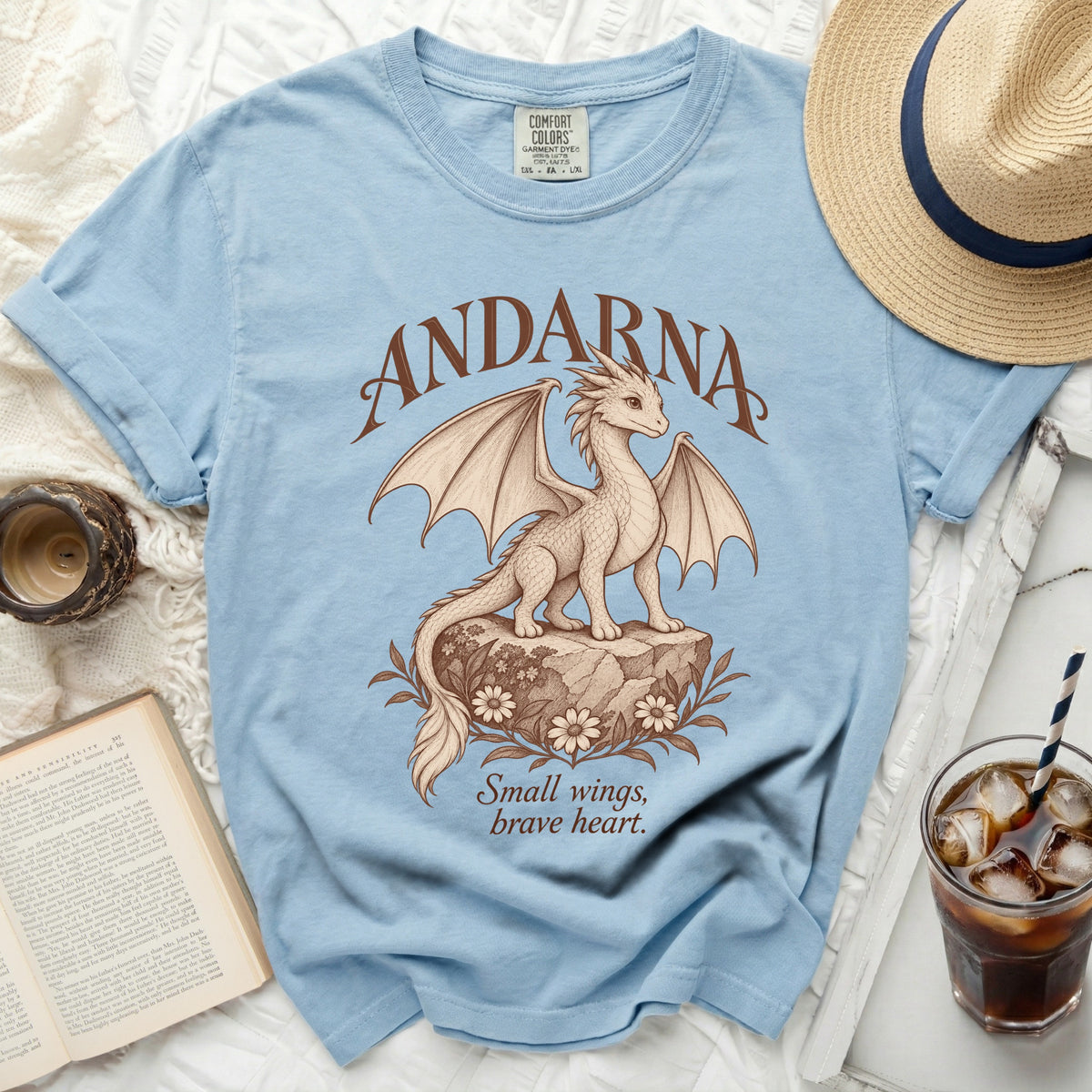 Light blue t-shirt with a dragon graphic, reads "ANDARNA" and "Small wings, brave heart."