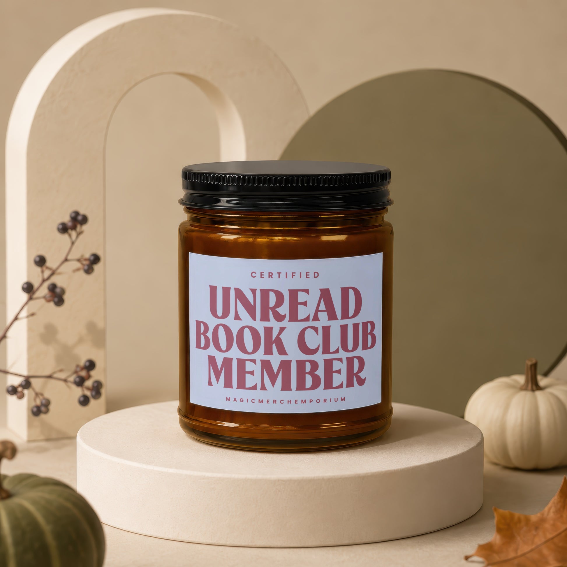 Amber jar candle with "CERTIFIED UNREAD BOOK CLUB MEMBER" text on a pedestal.