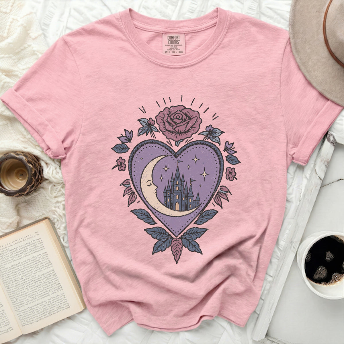 Pink t-shirt with a heart-shaped graphic featuring a crescent moon and castle.
